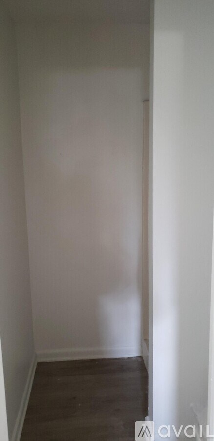 A white wall with a wooden floor.