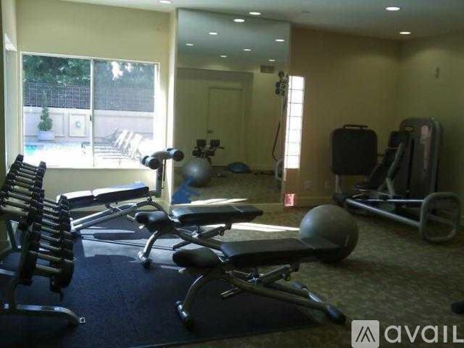 A gym with a variety of equipment including a bench press, a leg press, and a rowing machine.