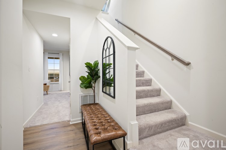A staircase with a brown bench and a plant on the landing.