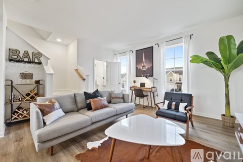 A living room with a grey couch and a black chair.