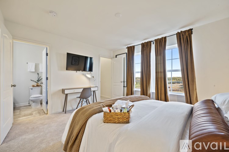 A bedroom with a large bed and a desk with a chair.