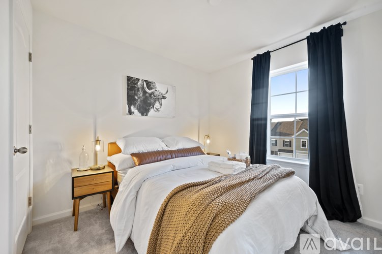 A bedroom with a large bed and a painting of a bull on the wall.