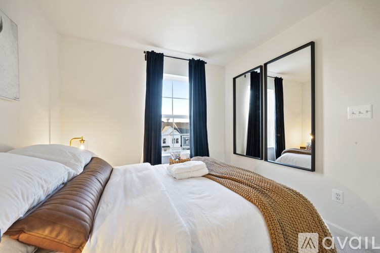 A bedroom with a large bed and a mirror on the wall.