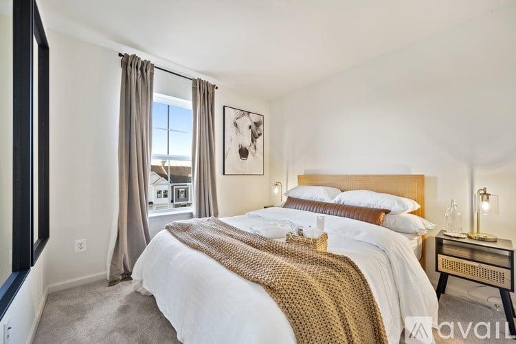 A bedroom with a large bed and a view of the outside through the window.