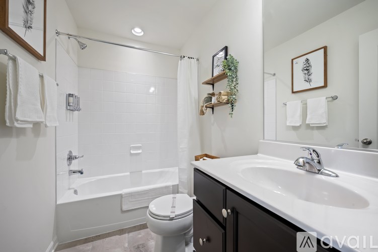 A bathroom with a white tub, sink, and toilet.
