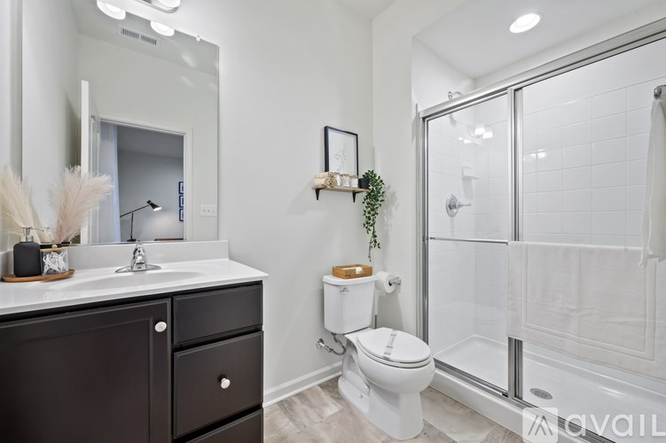 A white toilet sits in a bathroom next to a walk-in shower.