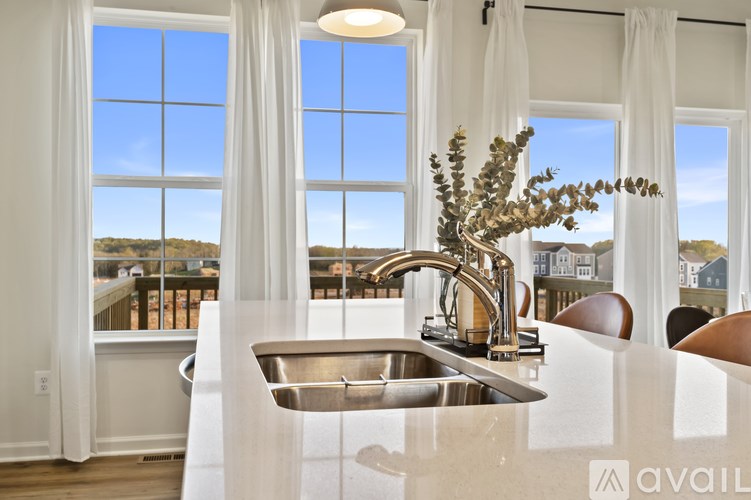 A kitchen with a large window overlooking a view of the ocean.