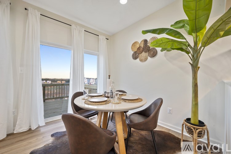 A dining room with a table set for two and a view of a balcony.