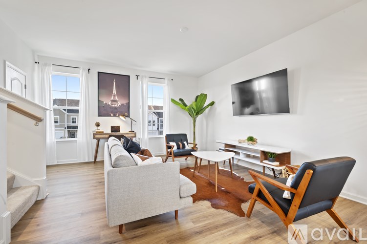 A living room with a couch, chair, and a television.