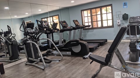 A gym with treadmills, elliptical machines, and other exercise equipment.