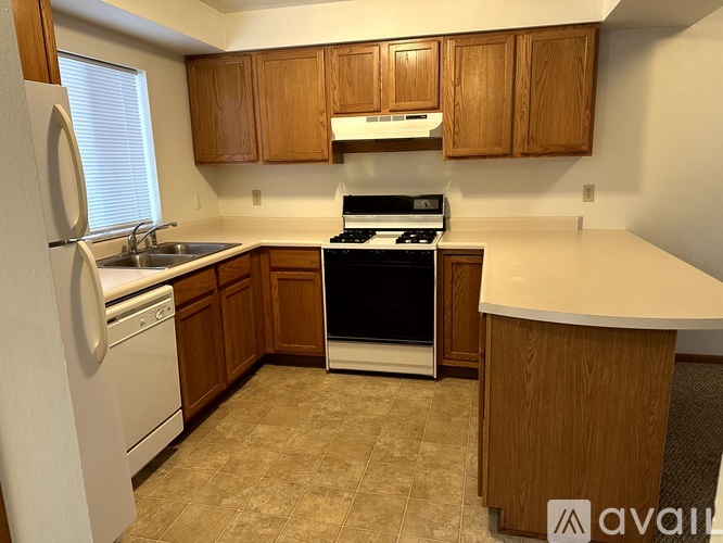 A kitchen with wooden cabinets and a white countertop.
