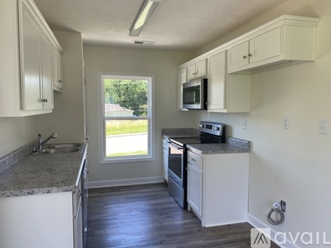 A kitchen with white cabinets and a granite countertop.