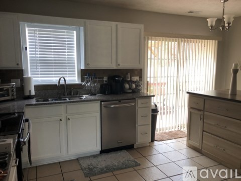 A kitchen with white cabinets and a black stove top oven.