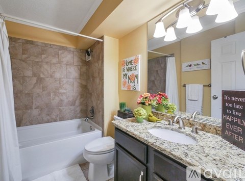 A bathroom with a toilet, sink, and tub.