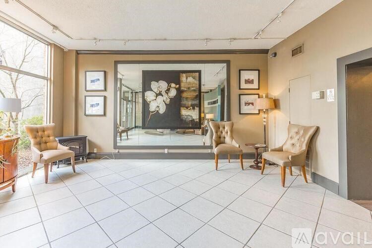 A living room with a large painting, two chairs, and a table.