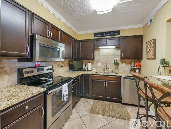 A kitchen with brown cabinets and a sign that says "Home Sweet Home".