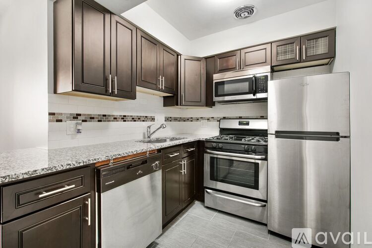 A kitchen with dark brown cabinets and stainless steel appliances.