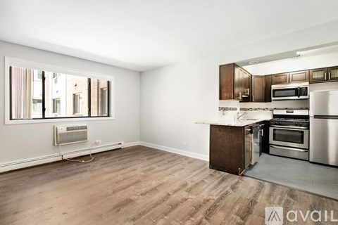 A kitchen with a wooden floor and stainless steel appliances.