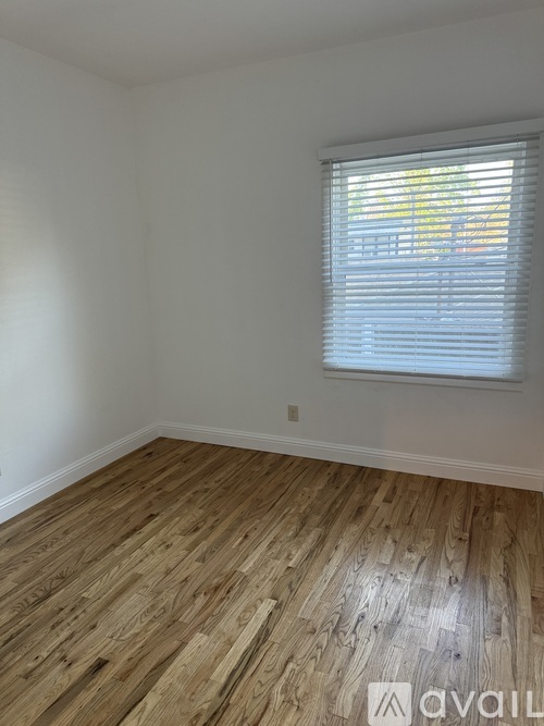 A room with a tiled floor and a window with blinds.