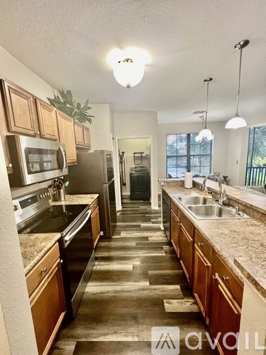 A kitchen with wooden cabinets and granite countertops.