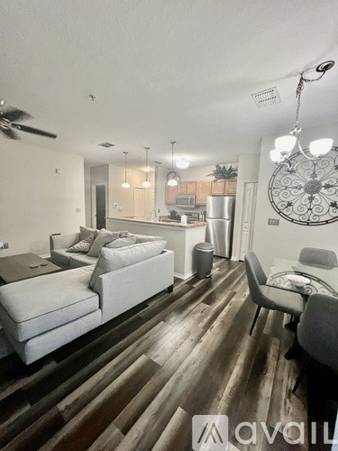 A living room with a white couch and a wooden floor.