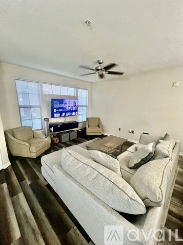 A living room with a couch, chair, and television.