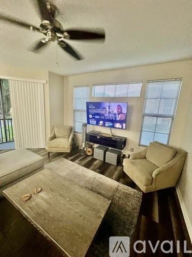 A living room with a television, a couch, and a coffee table.