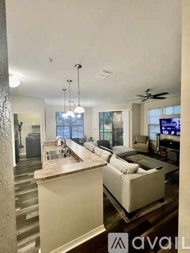 A modern kitchen with a bar area and a living room area.