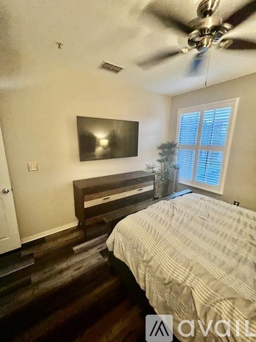 A bedroom with a bed, dresser, and a ceiling fan.