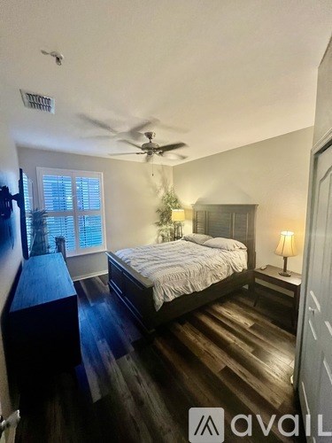 A bedroom with a bed, nightstand, and window.