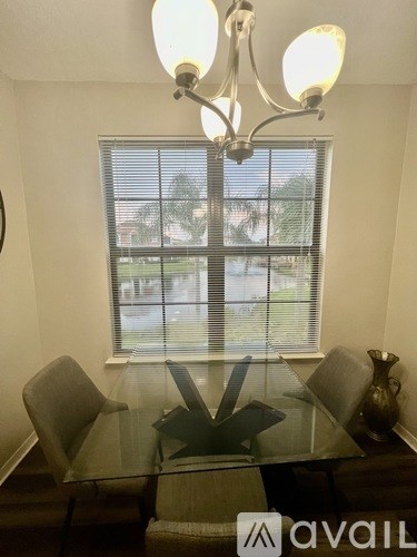 A dining room with a glass table and chairs and a chandelier.
