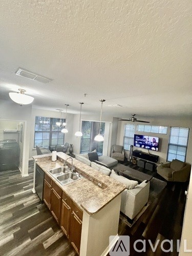 A modern kitchen with a granite countertop and a television.