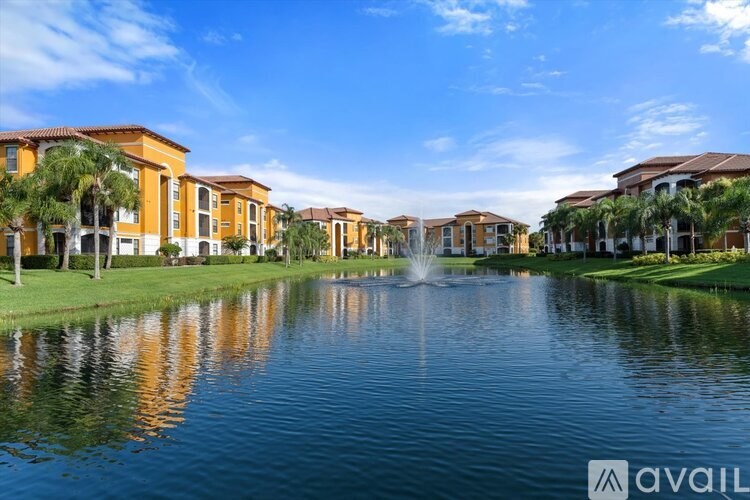 A row of houses with a fountain in the middle of a lake.