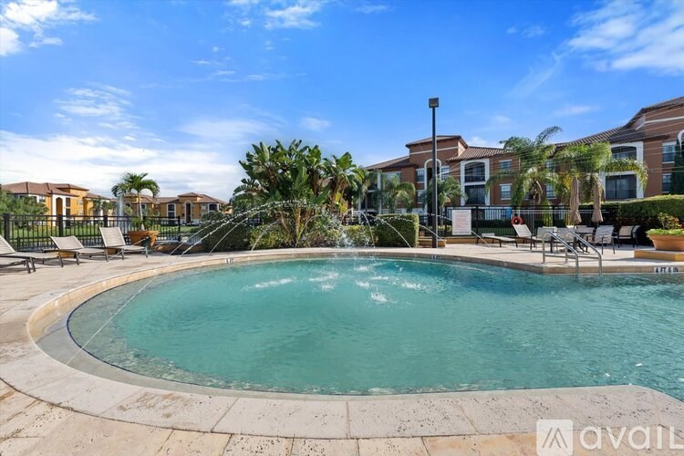 A pool surrounded by palm trees and lounge chairs.