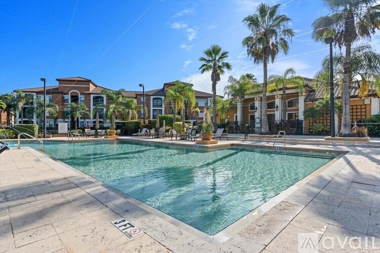 A swimming pool surrounded by palm trees and buildings.