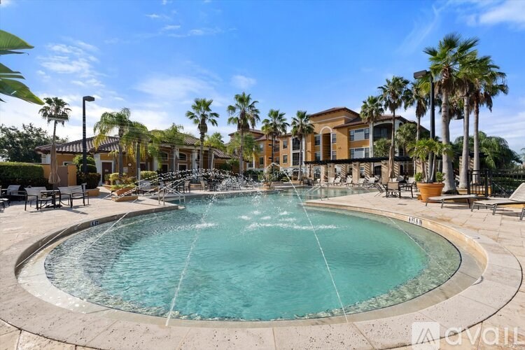 A large outdoor swimming pool surrounded by palm trees and lounge chairs.