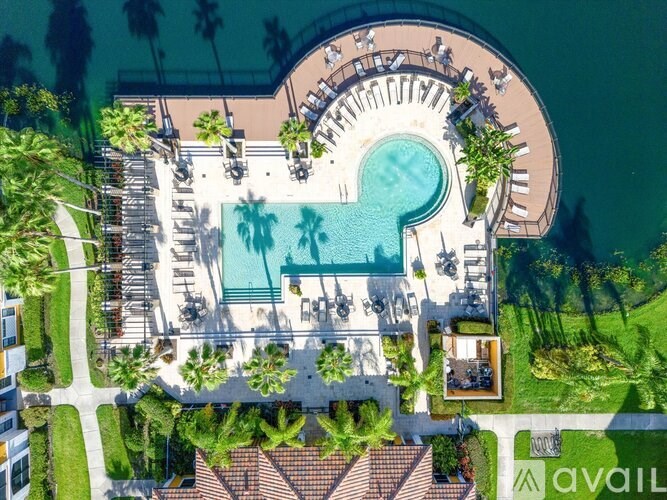 An aerial view of a resort with a pool and palm trees.