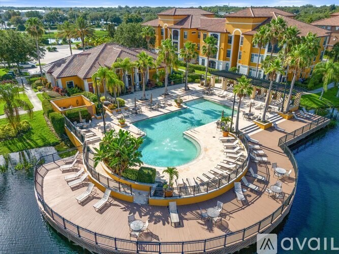 A large, luxurious pool surrounded by a deck with lounge chairs.