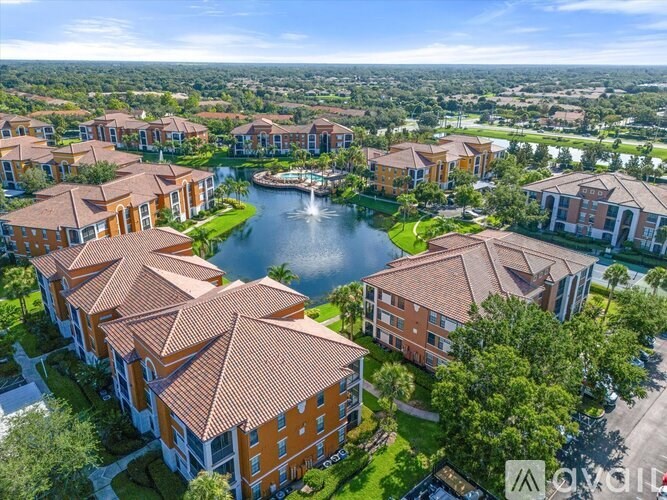 A bird's eye view of a residential area with a lake and houses.