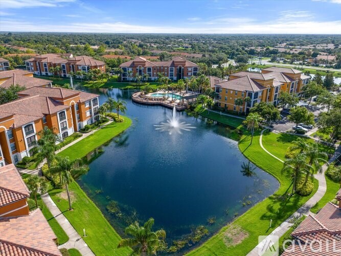 A bird's eye view of a resort with a fountain in the middle of a lake.