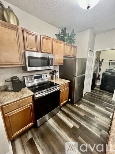 A kitchen with wooden cabinets and a stainless steel oven.