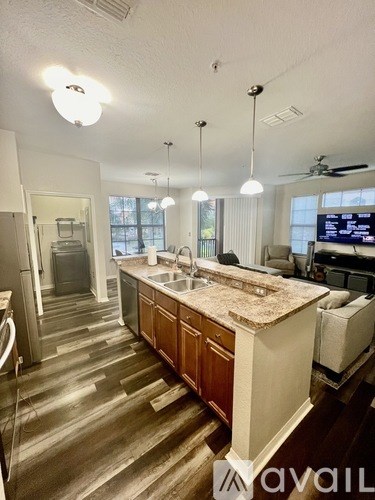 A kitchen with wooden cabinets and a marble countertop.