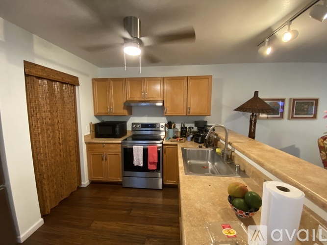 A kitchen with wooden cabinets and a stainless steel refrigerator.