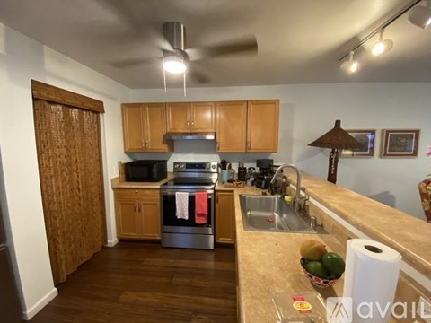 A kitchen with wooden cabinets and a stainless steel refrigerator.