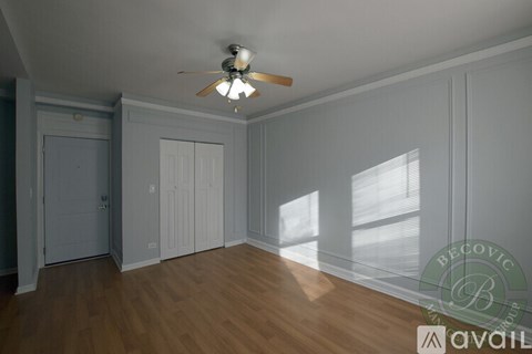 A room with a ceiling fan and wooden flooring.