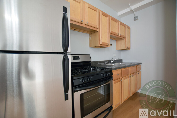 A modern kitchen with a stainless steel refrigerator and wooden cabinets.