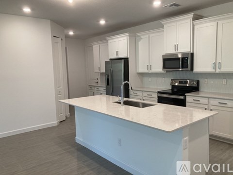 A kitchen with white cabinets and a large island.