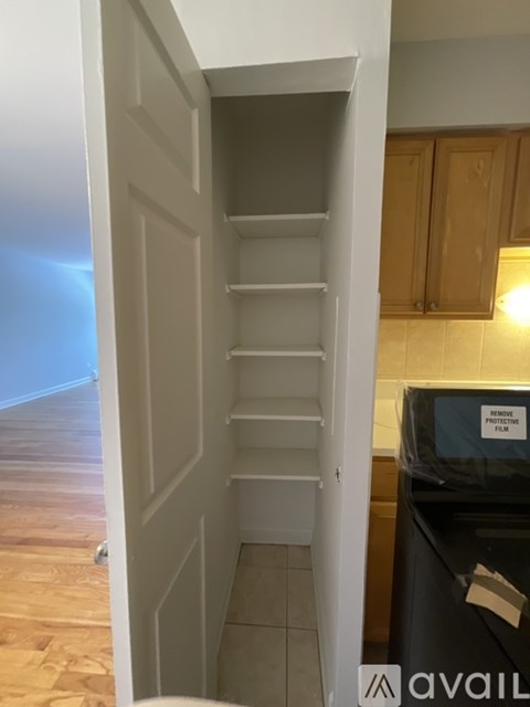 A kitchen with a black fridge and wooden cabinets.