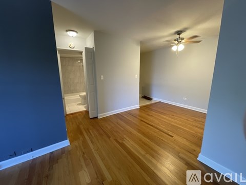A room with wooden flooring and a ceiling fan.
