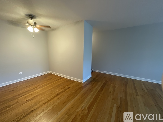 A room with wooden flooring and a ceiling fan.